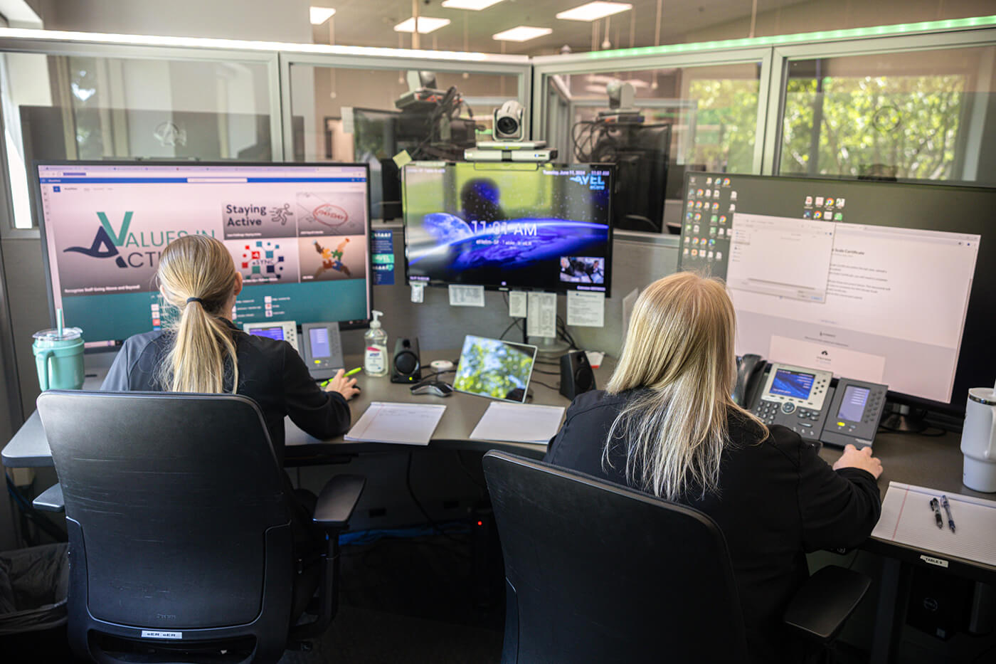Two Avel employees looking at computers at a desk